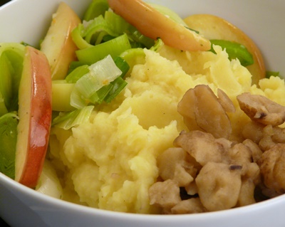 Schüssel mit veganem Kartoffelbrei, Apfel-Lauch-Gemüse und Maronen